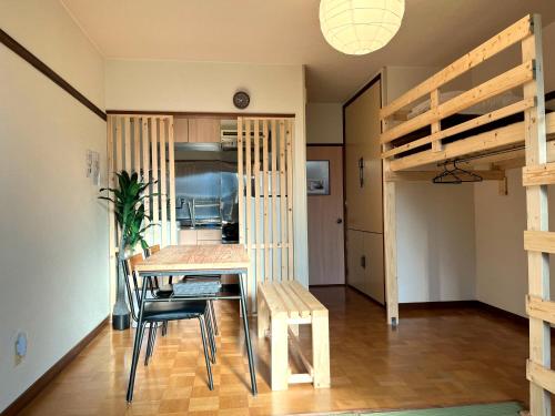 - une salle à manger avec une table, des chaises et des lits superposés dans l'établissement City YUNOKAWA Vacation stay, à Hakodate