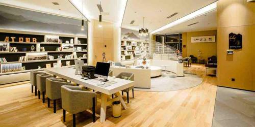 a library with a table and chairs and a desk at Atour Hotel Qinhuangdao Xiangxi Sea in Qinhuangdao