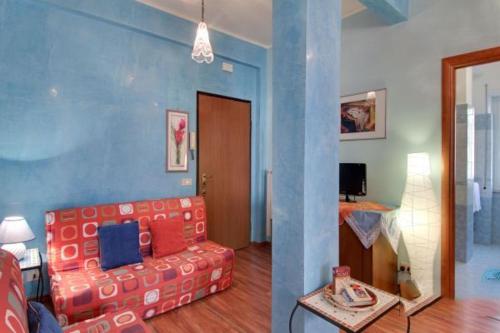 ローマにあるOlimpia Apartmentの赤いソファと青い壁のリビングルーム