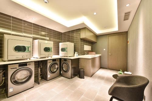 a laundry room with three washer and dryer at Atour Hotel Tianjin Binhai 1st Street in Binhai