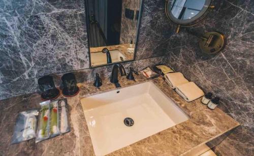 een badkamer met een wastafel en een spiegel bij The Drama in Shanghai