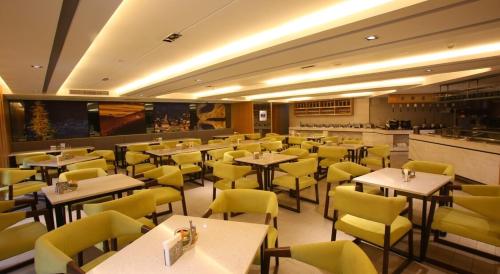Atour Hotel Chengdu Consulate South Renmin Road في تشنغدو: غرفة طعام مع طاولات وكراسي صفراء