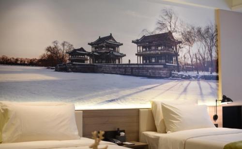 una habitación de hotel con una foto de dos edificios chinos en Atour Hotel Beijing Yansha Sanyuan Bridge en Pekín