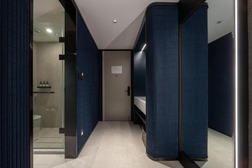 uma casa de banho com paredes em azulejos azuis e um WC. em Atour Light Hotel Jinan Harmony Square Provincial Hospital em Jinan