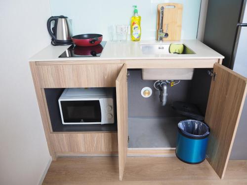 a small kitchen with a sink and a microwave at 1BR Siamese素坤逸87 Loft 空中酒吧 高层景观 BTS On Nut in Bangkok