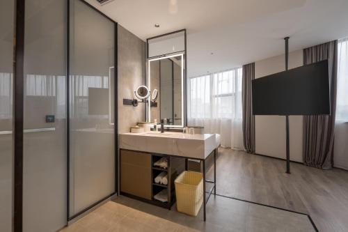 a bathroom with a sink and a mirror at Atour Hotel Xiamen North Station Jiageng Stadium in Xiamen