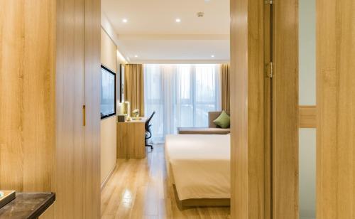 a bedroom with a bed and a desk and a television at Atour Hotel Hangzhou West Lake Cultural Plaza Shangtang Road in Hangzhou