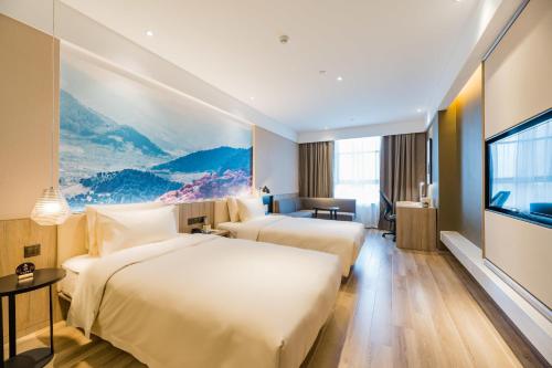a hotel room with two beds and a flat screen tv at Atour Hotel Ningbo International Convention and Exhibition Center in Ningbo