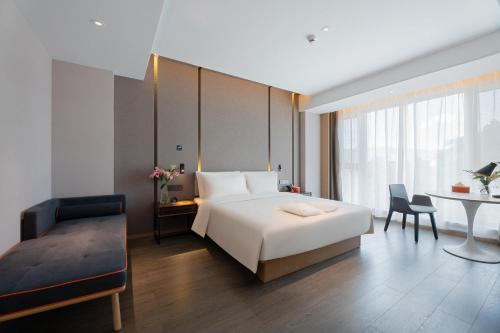 - une chambre avec un lit, un bureau et une table dans l'établissement Atour Hotel Lijiang Old Town Waterwheel, à Lijiang
