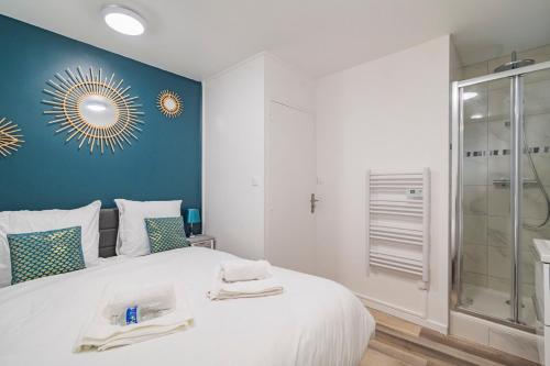 a bedroom with a large white bed with a glass shower at Pauline's Home Gambetta - Proche Cathédrale - Calme in Reims