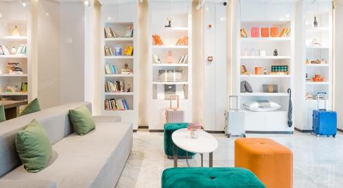 a living room with a couch and a table and shelves at Atour Hotel Hangzhou West Lake Cultural Plaza Shangtang Road in Hangzhou