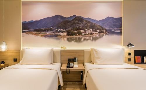 2 Betten in einem Hotelzimmer mit Wandgemälde in der Unterkunft Atour Hotel Hefei South Station Binhu Convention and Exhibition Center in Hefei