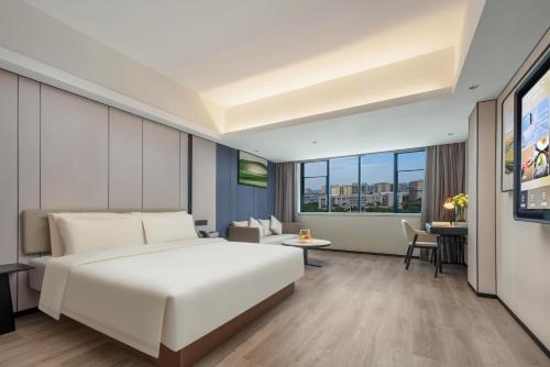 a hotel room with a white bed and a tv at Atour X Hotel Xiamen SM Plaza District Government in Xiamen