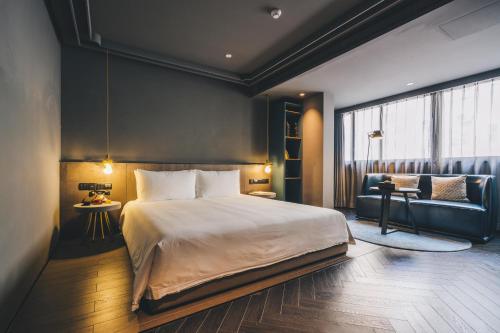 a bedroom with a large bed and a couch at The Drama in Shanghai