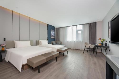 Cette chambre comprend 2 lits et une télévision. dans l'établissement Atour Hotel Karamay, à Karamay