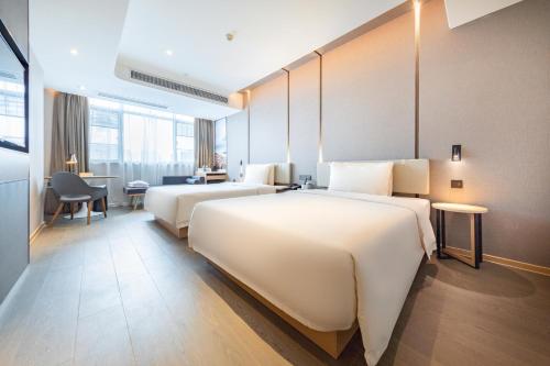 Cette chambre comprend deux lits et un bureau. dans l'établissement Atour Hotel Foshan Shunde Country Garden, à Shunde