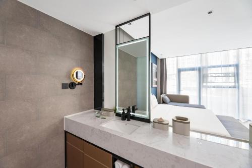 a bathroom with a sink and a large mirror at Atour Hotel Karamay in Karamay