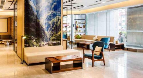 a lobby with a couch and a table and chairs at Atour Hotel Shenzhen Nanshan Coast City in Shenzhen