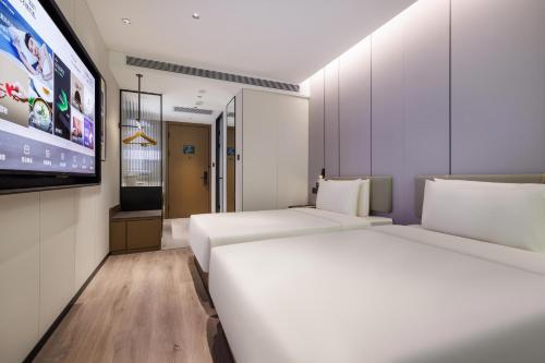 um quarto de hotel com duas camas e uma televisão de ecrã plano em Atour Hotel Beijing South Xizhan Road em Pequim