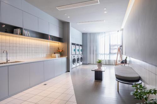 uma cozinha com um lavatório e um banco num quarto em Atour Hotel Hefei Pearl Plaza Huijin Business Center em Hefei