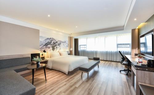 a hotel room with a bed and a couch at Atour Hotel Tianjin Binhai 1st Street in Binhai