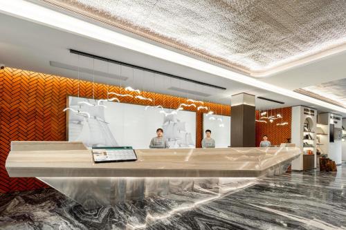 een lobby met twee mannen in een kamer bij Atour Hotel Quanzhou Jinjiang Sunshine Plaza in Jinjiang
