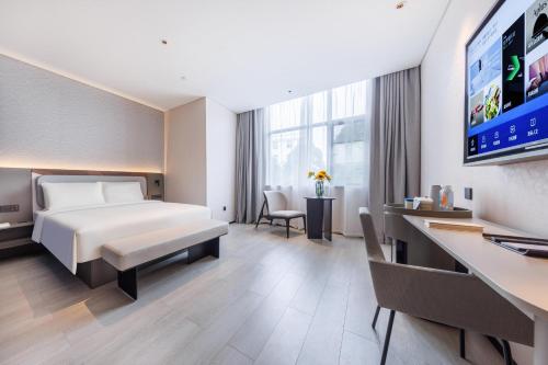 um quarto de hotel com uma cama e uma secretária em Atour Light Hotel Kunming Dianchi Road South Asia Style First City em Kunming