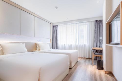 a hotel room with two beds and a window at Atour Hotel Xiamen Xiagu Cruise Center in Xiamen