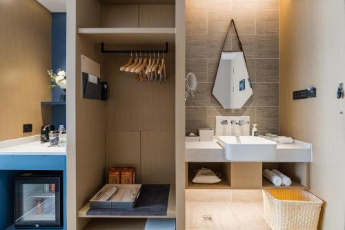 W łazience znajduje się umywalka i lustro. w obiekcie Atour Hotel Handan New Century w Handan