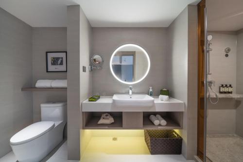 bagno con lavandino, servizi igienici e specchio di Atour Light Hotel Guiyang Fountain a Guiyang
