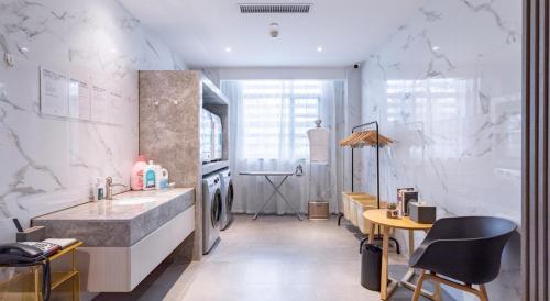 La salle de bains est pourvue d'un lavabo et d'un comptoir avec des chaises. dans l'établissement Atour Hotel Guangzhou Huadu Square, à Huadu