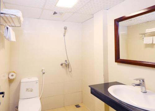 een badkamer met een toilet, een wastafel en een spiegel bij Bing Sapa Hotel in Sa Pa
