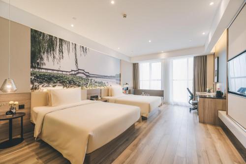 a hotel room with two beds and a desk at Atour Hotel Shanghai Minhang Industrial Park in Shanghai