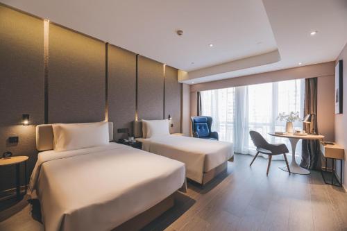 a hotel room with two beds and a table at Atour S Hotel Shanghai Xujiahui Tianyaoqiao in Shanghai