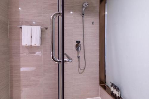 a bathroom with a shower with a glass door at Atour Hotel Xiamen Xiagu Cruise Center in Xiamen