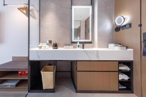 a bathroom with a white sink and a mirror at Atour Hotel Jinan Shungeng Covention and Exhibition Center Bayi Overpass in Jinan