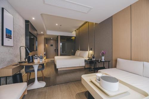 a hotel room with a bed and a table at Atour Hotel Shanghai The Bund East Nanjing Road in Shanghai