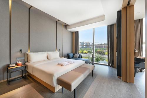 a hotel room with a bed and a large window at Atour Hotel Tianjin Eye in Tianjin