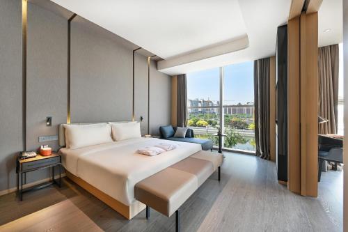 une chambre d'hôtel avec un lit et une grande fenêtre dans l'établissement Atour Hotel Tianjin Eye, à Tianjin