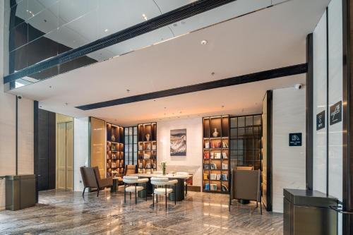 a library with a table and chairs and bookshelves at Atour Hotel Shenzhen Luohu Vientiane City in Shenzhen