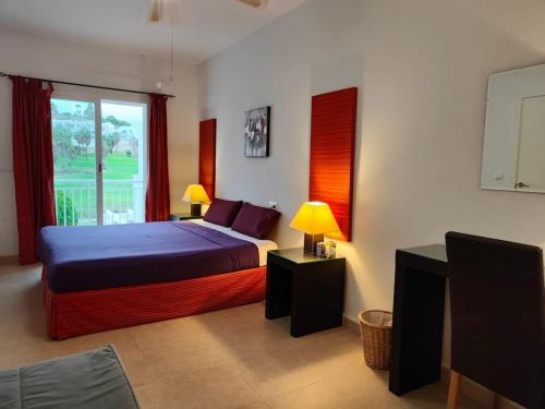 a bedroom with a bed with two lamps and a window at Spacious and luxurious apartment in Mojácar