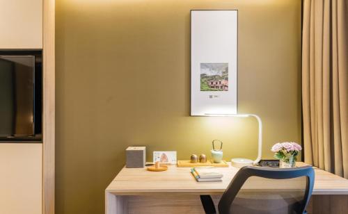a desk with a chair and a lamp in a room at Atour Hotel Hangzhou West Lake Cultural Plaza Shangtang Road in Hangzhou