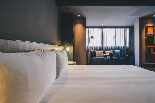 a hotel room with a bed and a chair at The Drama in Shanghai