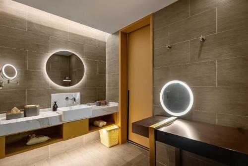 Baño con 2 lavabos y espejo en Atour S Hotel Xining Haihu New District SDIC Plaza en Xining