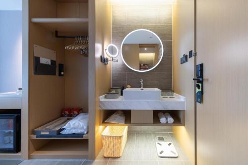 a bathroom with a sink and a mirror at Atour Hotel Urumqi Airport Degang Wanda in Ürümqi