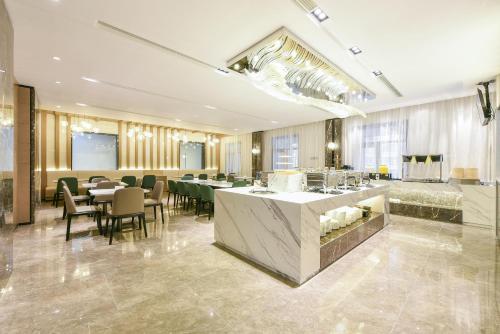 a restaurant with a bar and tables and chairs at Atour Hotel Beijing Wangjing 798 Art District in Beijing