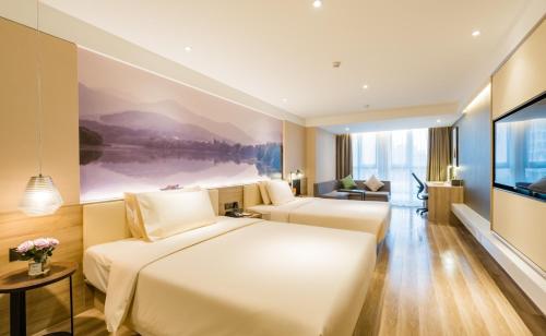 a hotel room with two beds and a flat screen tv at Atour Hotel Hangzhou West Lake Cultural Plaza Shangtang Road in Hangzhou