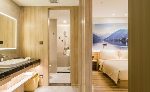a bathroom with a bed and a shower and a sink at Atour Hotel Hangzhou West Lake Cultural Plaza Shangtang Road in Hangzhou