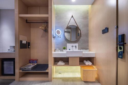 La salle de bains est pourvue d'un lavabo et d'un miroir. dans l'établissement Atour Hotel Hefei North Square South Station, à Hefei