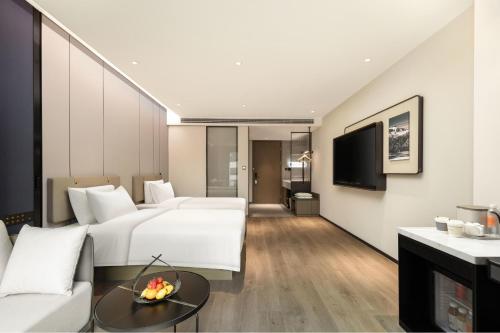a hotel room with two beds and a tv at Atour Hotel Quanzhou Jinjiang Sunshine Plaza in Jinjiang